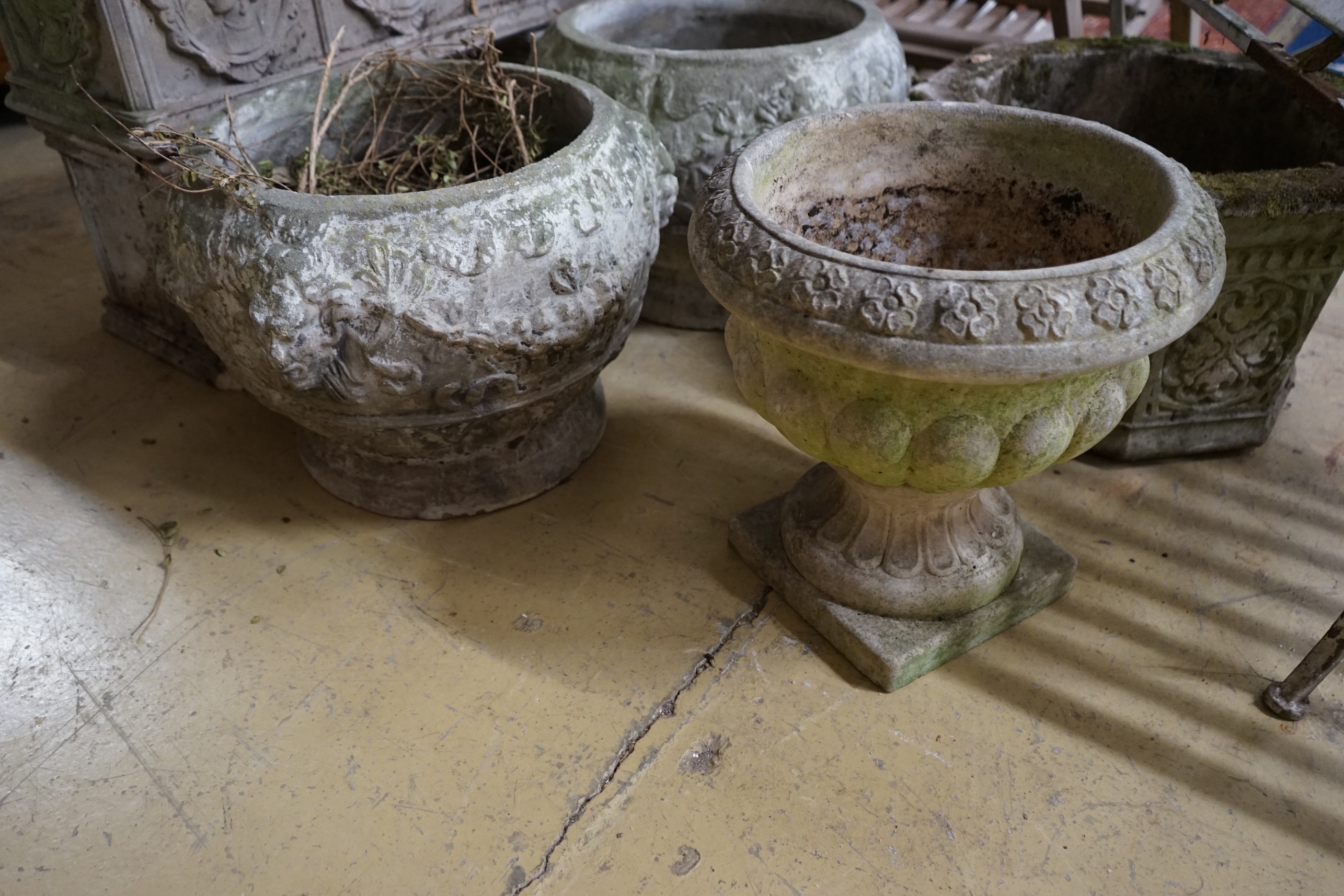 A rectangular reconstituted stone garden planter on twin block supports, width 70cm, a hexagonal garden planter and three circular garden planters